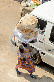 Unidentified Ghanaian woman carries boxes on her head at the Ku