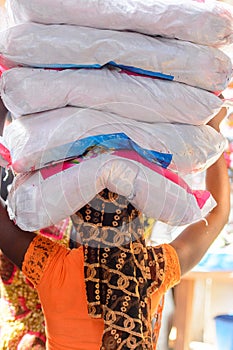 Unidentified Ghanaian woman carries plastic bags on her head at