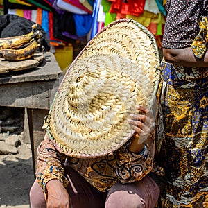 Unidentified Ghanaian woman hides behind the hat at the Kumasi