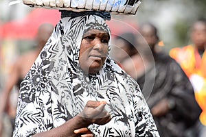 Unidentified Ghanaian woman in paranja carries a basket on her