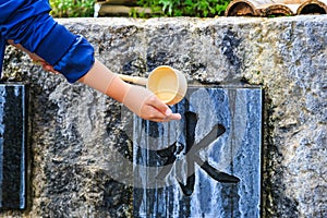 Unidentified Japanese people washing hand at fountain before giving the worship