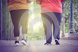 Unidentified legs of fat people jogging at park