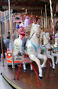 Unidentified Little Girl enjoying Carousel Merry go round ride at Christmas Market