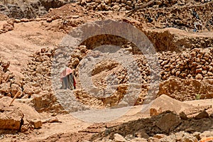 Unidentified local man collects clay for building houses.