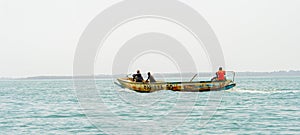 Unidentified local people sail on the boat on the coast of the