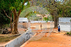 Unidentified local people walk along the street in a village of