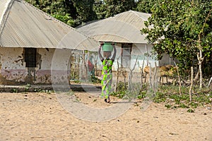 Unidentified local woman carries a basin in the Etigoca village
