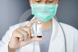 Unidentified male doctor holding a vaccine bottle