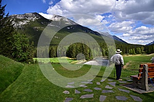 An unidentified man is playing golf in middle of amazing landscapes.