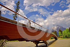 An unidentified man is riding a bicycle on a new bridge in banff national park i