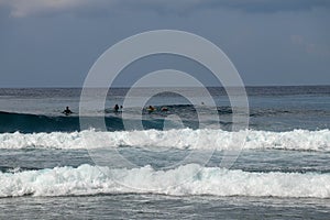 Unidentified man on surf board waiting for wave in blue water back view. Young Boys Waits the Waves. Surfer waiting in line for a