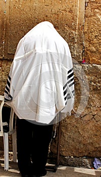 Unidentified man in tefillin praying at the Wailing wall (Western wall)