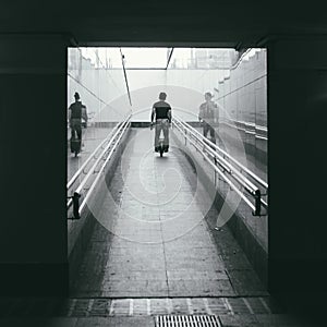 An unidentified middle-aged man rides a monocycle up a ramp in the underpass. Rear view. personal transport of the