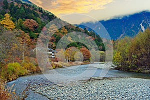 the unidentified mountain resort hotel in the background of Azusa river and colorful autumn trees at Kamikochi, Nagano pref.