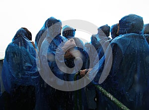 Unidentified people in blue rain coats enjoying