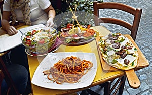 Unidentified people eating traditional italian food in outdoor restaurant