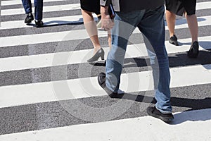 Unidentified people legs crossing street