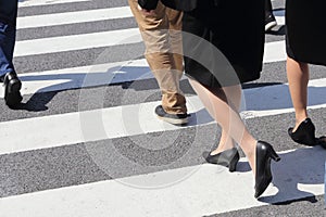 Unidentified people legs crossing street