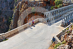 Unidentified people visit famous truss bridge over Aradena Gorge on Crete Island, Greece