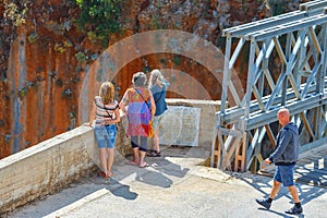 Unidentified people visit famous truss bridge over Aradena Gorge on Crete Island, Greece