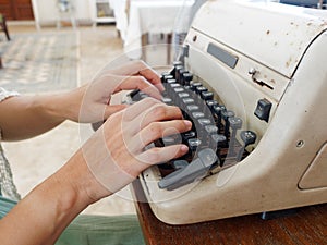 Unidentified personâ€™s hand typing on retro typing machine