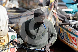 Unidentified Senegalese man holds a fishing net on the coast of