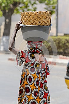 Unidentified Senegalese woman carries a basin on her head in th