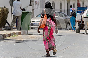 Unidentified Senegalese woman walks along the street in the cen