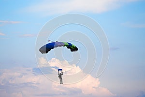 Unidentified skydiver, parachutist on blue sky