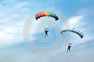 Unidentified skydivers on blue sky photo