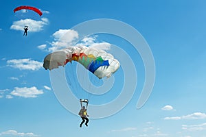 Unidentified skydivers on blue sky