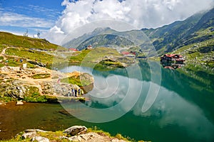 Unidentified tourists enjoy the sights of Balea Lake at 2,034 m altitude in Fagaras Mountains