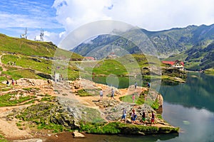 Unidentified tourists enjoy the sights of Balea Lake at 2,034 m altitude on July 21
