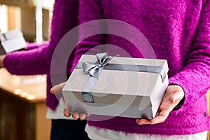 Unidentified woman holding a small gift. Concept of celebration