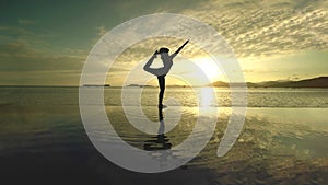 Unidentified woman practicing yoga on the beach