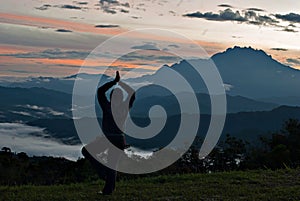 Unidentified woman practising yoga with Mount Kinabalu as background