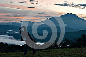 Unidentified woman stretching at the outdoor with Mount kinabalu as background