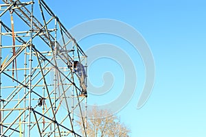 Unidentified worker assembles frame of outdoor stage