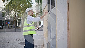 Uniform man checking building at construction site place. Foreman making notes