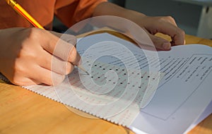 Uniform School Asian students taking exams writing answer optical form with pencil in high school classroom, view of having exams photo