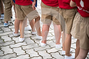 Uniformed children aligned legs