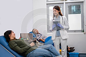 Uniformed female doctor carrying a tablet chatting with a patient