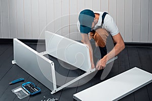 A uniformed worker collects a white metal shelving for storage in a warehouse or storeroom