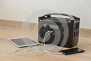 Uninterruptible power supply source. Portable power station charching tablet and smartphone
