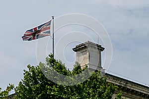 Union Jack - British flag waving on the top of roof with a selective focus on it.