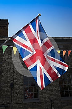 Union Jack and bunting backlit in market town