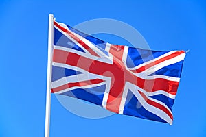 Union jack flag against a blue sky.