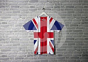 Union jack flag on shirt and hanging on the wall with brick pattern wallpaper