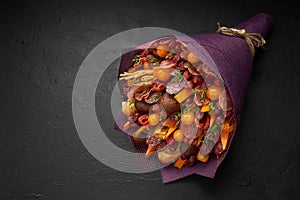 Unique bouquet for a man consisting of sausages, cheese, tomatoes and dark bread on the black background
