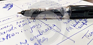 Unique close-up shot of a fountain pen with random texts on the paper below - Writing concept fit for representing Chief News